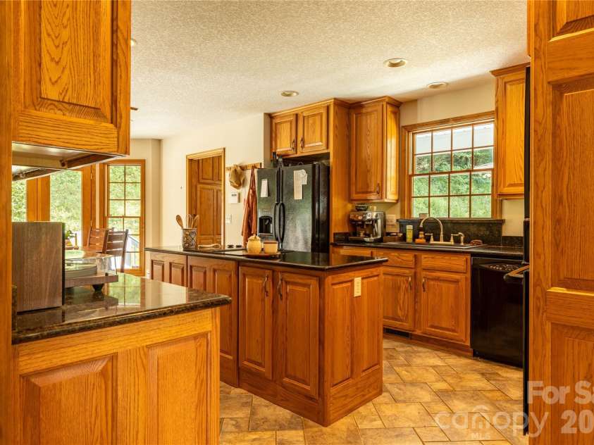 226 Wildcat Mountain Trail, Sylva, NC 28779.  MLS# CAR4284312, YatesRealty ID 12873. Spacious kitchen with granite countertops, island, and tiled floor