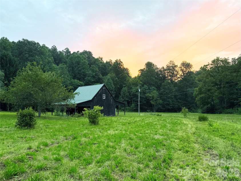226 Wildcat Mountain Trail, Sylva, NC 28779.  MLS# CAR4284312, YatesRealty ID 12873. Sunset view over the barn and trees