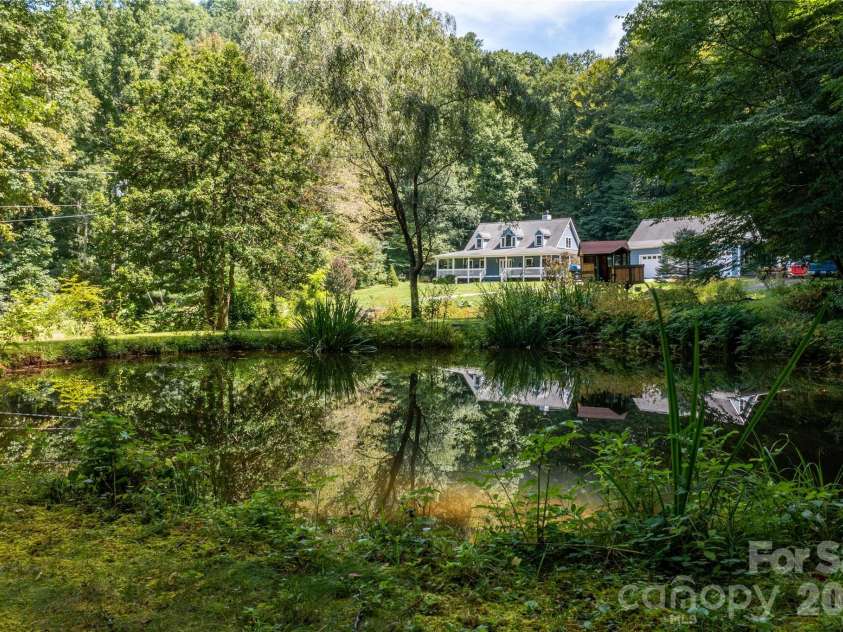 226 Wildcat Mountain Trail, Sylva, NC 28779.  MLS# CAR4284312, YatesRealty ID 12873. View of home and workshop from behind the pond