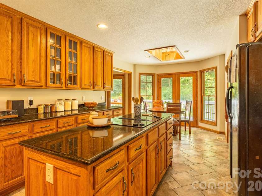 226 Wildcat Mountain Trail, Sylva, NC 28779.  MLS# CAR4284312, YatesRealty ID 12873. View of light filled kitchen looking out onto the back deck
