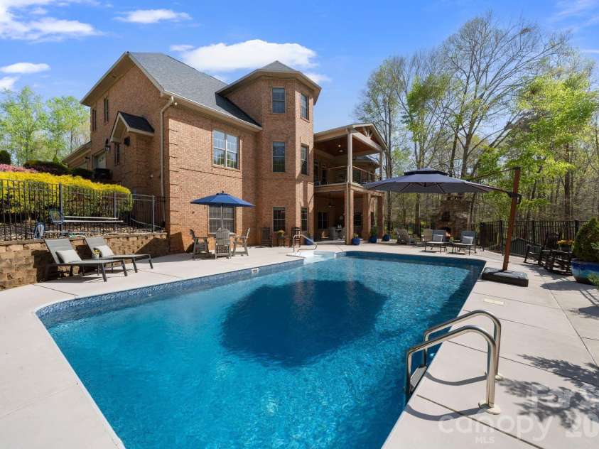 183 April Road, Troutman, NC 28166.  MLS# CAR4365014, YatesRealty ID 12908. Backyard retreat features, heated pool, fireplace, and BBQ under the covered patio + Private dock