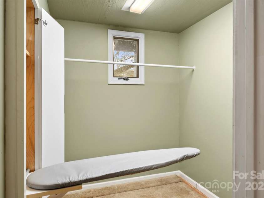 31 Cedarwood Lane, Asheville, NC 28803.  MLS# CAR4126621, YatesRealty ID 12943. One of Two walk in closets in the downstairs owners suite with built in ironing board.
