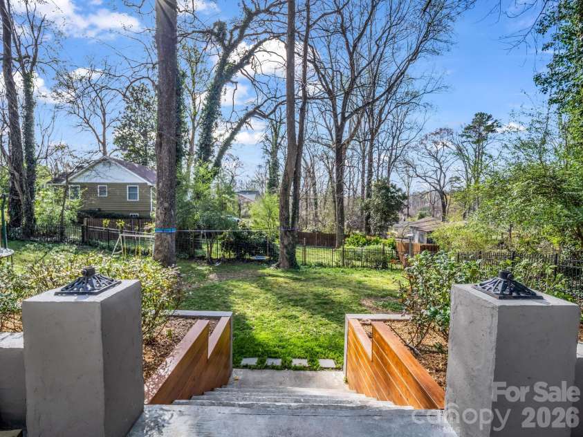 54 Broadway Avenue, Tryon, NC 28782.  MLS# CAR4357107, YatesRealty ID 12954. Steps leading from the patio to the yard