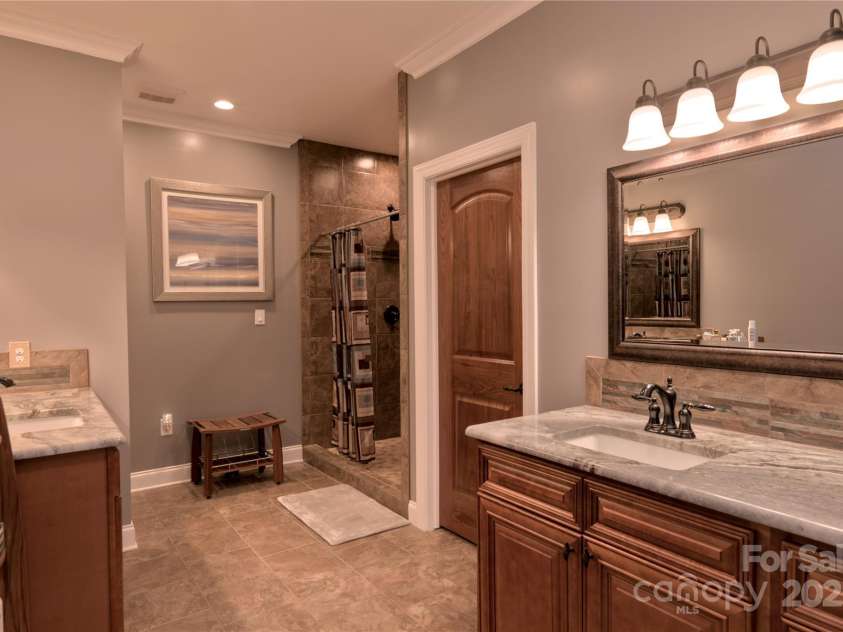 15027 Beatties Ford Road, Huntersville, NC 28078.  MLS# CAR4308450, YatesRealty ID 1303. Large primary bathroom with custom tile, granite