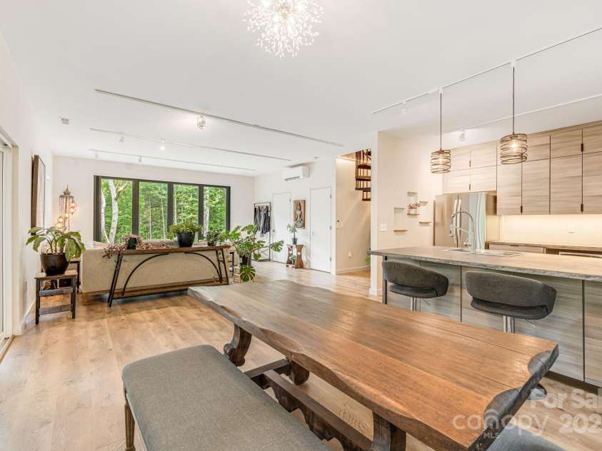 47 Webb Cove Road, Asheville, NC 28804.  MLS# CAR4234951, YatesRealty ID 13033. View from corner behind the dining table looking out to living area and the all glass accordian doors