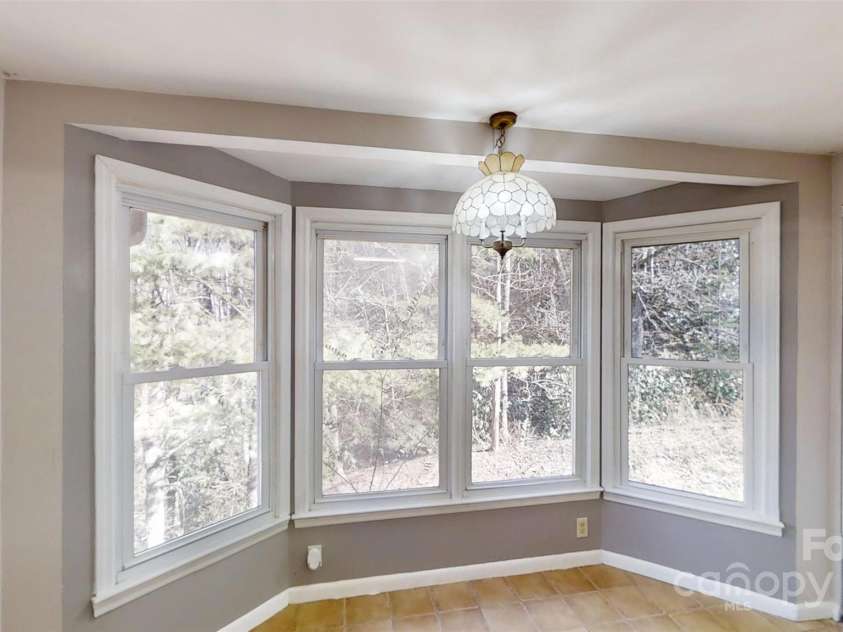 59 Upper Saw Branch Road, Candler, NC 28715.  MLS# CAR4226917, YatesRealty ID 13059. Dining room side picture window to view creek/pond