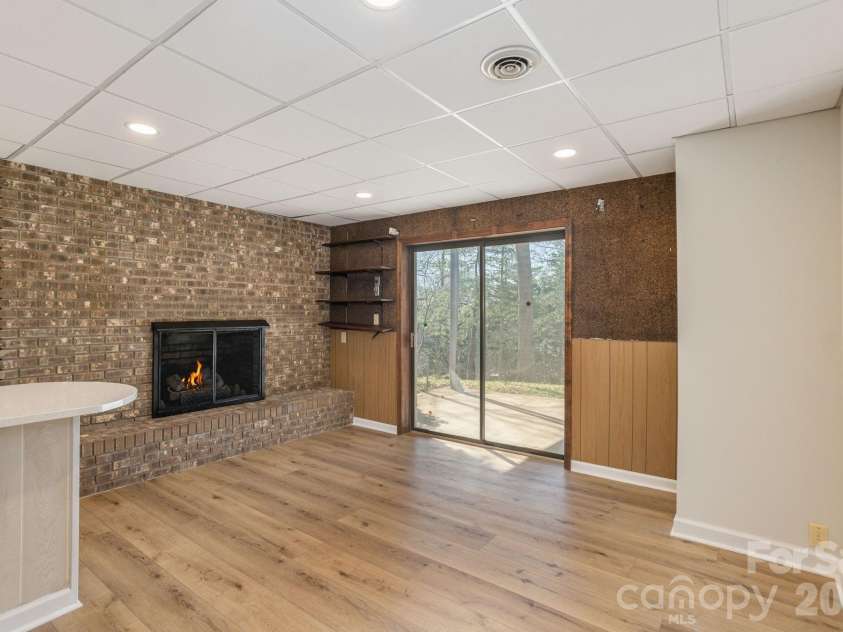 3113 Primrose Drive, Hendersonville, NC 28792.  MLS# CAR4359967, YatesRealty ID 13099. Lower level den with fireplace