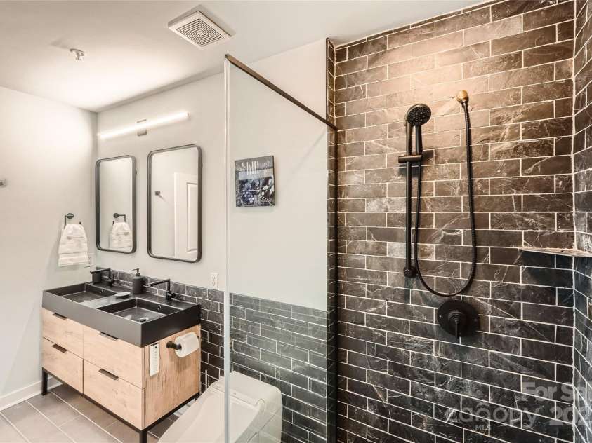 210 Church Street, Charlotte, NC 28202.  MLS# CAR4308241, YatesRealty ID 1314. Renovated en-suite bath w/ luxurious tiled shower