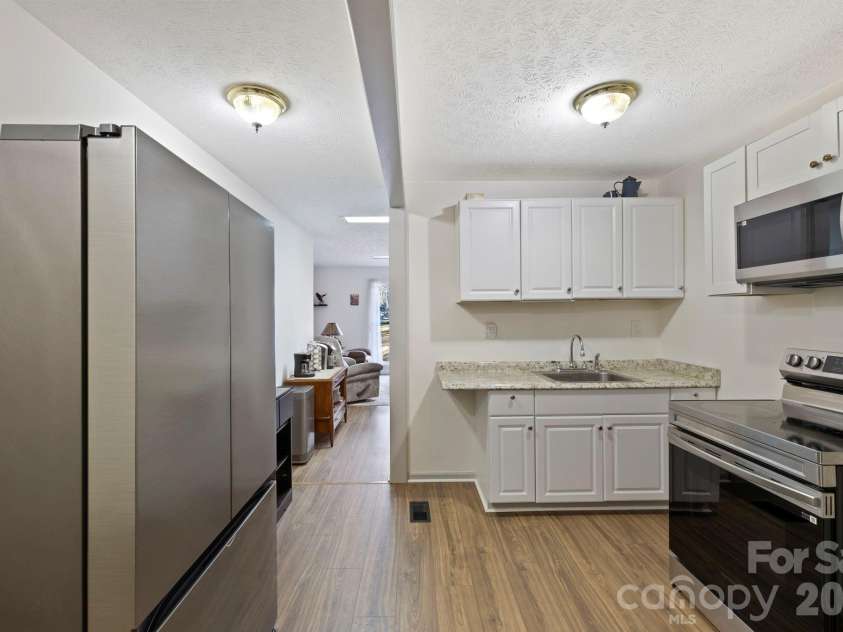 40 Country Bear Lane, Flat Rock, NC 28731.  MLS# CAR4332498, YatesRealty ID 13148. Unit 2 - Kitchen with range, microwave and refrigerator