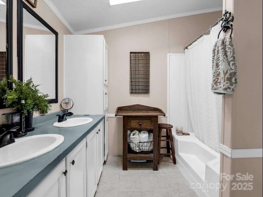 243 Buffalo Creek Road, Lake Lure, NC 28746.  MLS# CAR4219032, YatesRealty ID 13241. Spacious en suite primary bathroom with double vanity and large tub & shower.