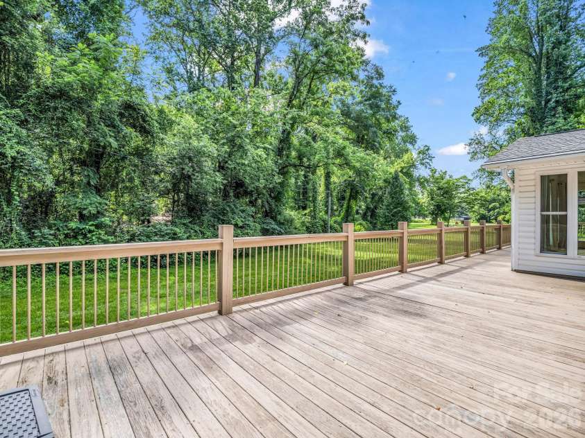 260 Warrior Drive, Tryon, NC 28782.  MLS# CAR4359501, YatesRealty ID 13291. Spacious back deck with a low maintenance yard that meanders along the water!