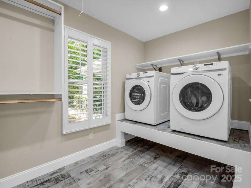 197 Hawthorne Drive, Lake Lure, NC 28746.  MLS# CAR4154813, YatesRealty ID 133. Laundry room adjoins the closet & primary ensuite bathroom. Laundry baskets fit underneath the washer and dryer.