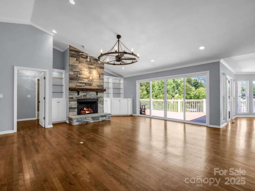 197 Hawthorne Drive, Lake Lure, NC 28746.  MLS# CAR4154813, YatesRealty ID 133. The open living room on the main level splits the floorplan with a guest room and full bathroom located opposite from the Primary ensuite bedroom. See virtually staged photos of the living room.