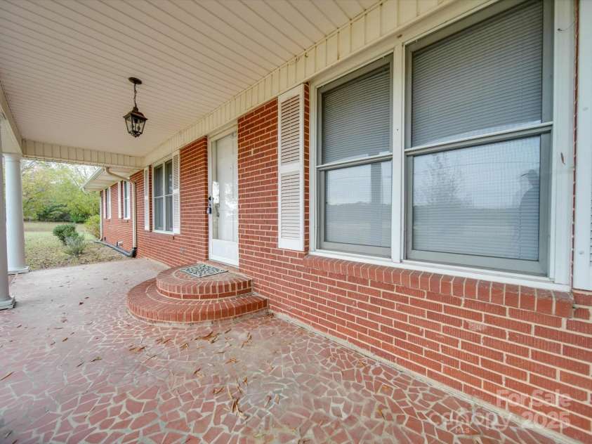 3113 Old Pageland Marshville Road, Wingate, NC 28174.  MLS# CAR4274721, YatesRealty ID 13332. Under front porch featuring rounded steps
