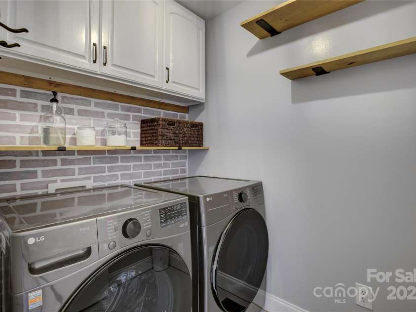 8322 Loma Linda Lane, Waxhaw, NC 28173.  MLS# CAR4238719, YatesRealty ID 13341. Laundry Room with brick accent wall and cabinets.