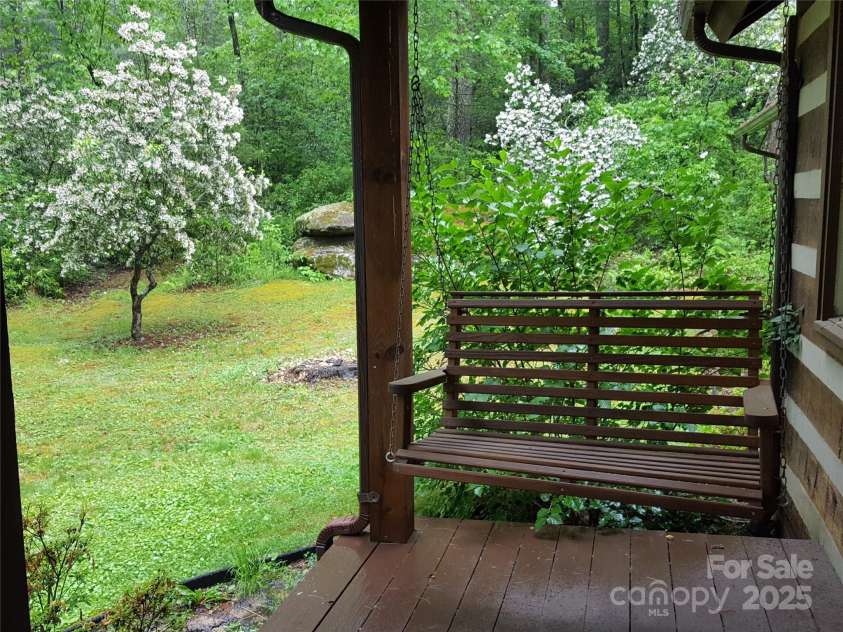 142 Cherrywood Lane, Pisgah Forest, NC 28768.  MLS# CAR4312423, YatesRealty ID 13342. Front porch swing looking toward the side yard