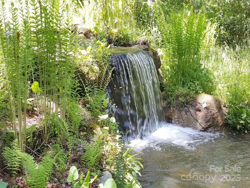 142 Cherrywood Lane, Pisgah Forest, NC 28768.  MLS# CAR4312423, YatesRealty ID 13342. Natural waterfall view from the back deck and yard.
