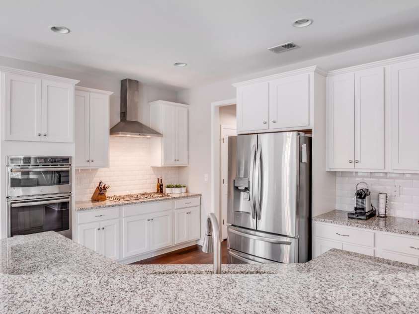220 Kenway Loop, Mooresville, NC 28117.  MLS# CAR4231089, YatesRealty ID 13351. Gorgeous bright kitchen with granite countertops, white cabinets, stainless steel appliances and gas stove.