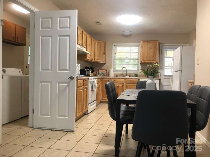 424 Creekside Drive, Asheville, NC 28804.  MLS# CAR4259883, YatesRealty ID 13362. Kitchen and informal dining area with door to laundry open. Home is now vacant.