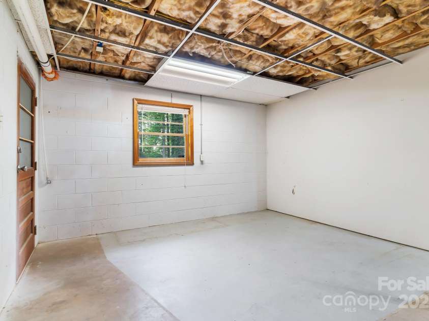 217 Royal Pines Drive, Arden, NC 28704.  MLS# CAR4257398, YatesRealty ID 13374. Imagine the possibilities for this daylight basement space. Door leads to single car garage.