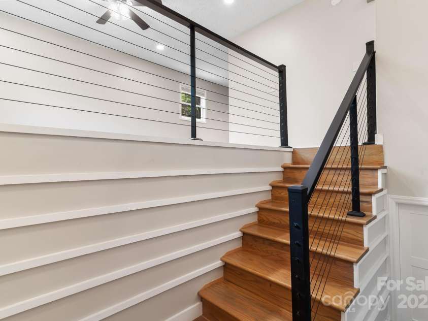 217 Royal Pines Drive, Arden, NC 28704.  MLS# CAR4257398, YatesRealty ID 13374. Stairs from living room to entry landing. Leads to door to basement space.