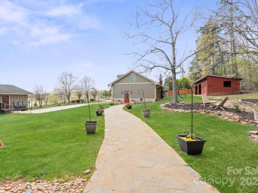 1620 London Road, Mooresville, NC 28115.  MLS# CAR4281112, YatesRealty ID 13387. A path from the guest house to the party barn.