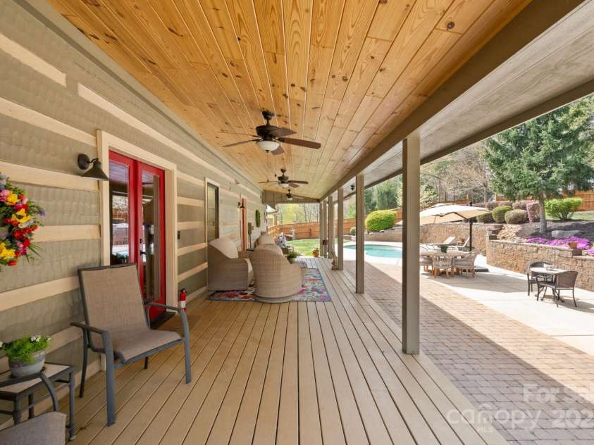 1620 London Road, Mooresville, NC 28115.  MLS# CAR4281112, YatesRealty ID 13387. The Back covered deck that Overlooks the backyard, saltwater, in-ground pool, and Koi Pond. There is over 1100 sq feet of covered porch space at the main residence.