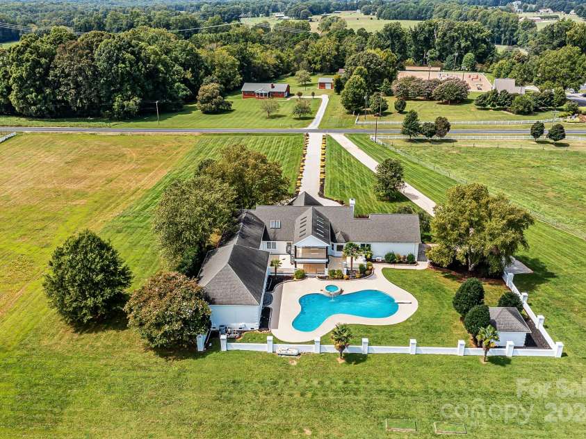 3245 Jackson Road, Mooresville, NC 28115.  MLS# CAR4161494, YatesRealty ID 13432. Aerial View of Spectacular, Custom, Modern, 2 Story Home with 2 Car Side Load Garage, Expansive Pool/Spa, located on 14 sprawling acres of level pasture land & surrounded by Equestrian properties!