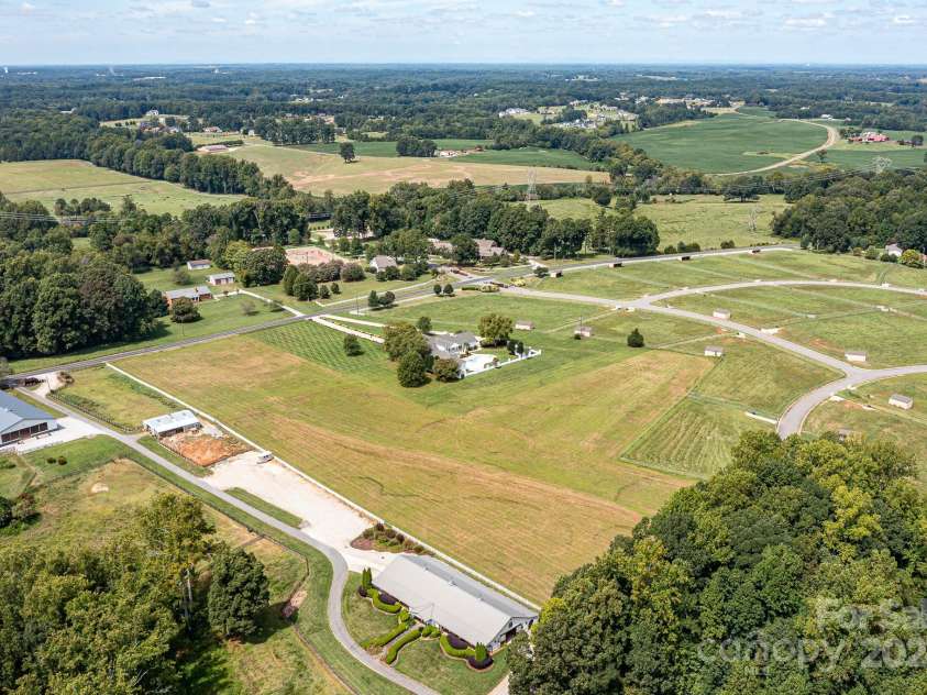 3245 Jackson Road, Mooresville, NC 28115.  MLS# CAR4161494, YatesRealty ID 13432. Aerial View of Spectacular, Custom, Modern, 2 Story Home with 2 Car Side Load Garage, Expansive Pool/Spa, located on 14 sprawling acres of level pasture land & surrounded by Equestrian properties!