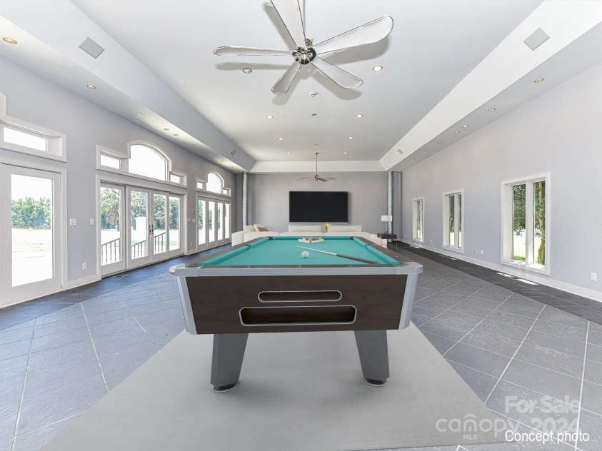 3245 Jackson Road, Mooresville, NC 28115.  MLS# CAR4161494, YatesRealty ID 13432. Recreation Room on main level with recessed lights, ceiling fan, tile floors, walls of windows & patio access!