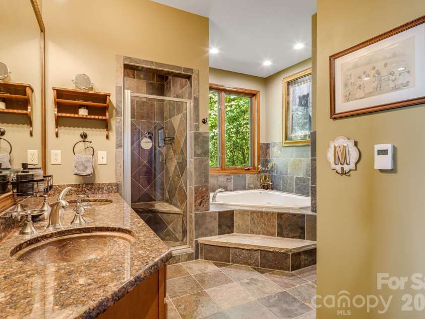 191 Ivy Way, Mars Hill, NC 28754.  MLS# CAR4308782, YatesRealty ID 1344. Main level ensuite primary bathroom with walk-in closets.