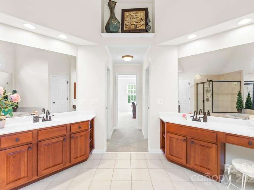 9311 St Barts Lane, Huntersville, NC 28078.  MLS# CAR4255582, YatesRealty ID 13449. Luxury Primary suite bathroom with soaring ceilings - dual vanities and his and her closets. Tile floors and new sink hardware!