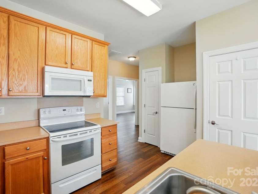 2323 Granville Place, Monroe, NC 28110.  MLS# CAR4256900, YatesRealty ID 13473. VIEW OF PANTRY, REFRIGERATOR(INCLUDED) AND LAUNDRY CLOSET FROM BAR (WASHER & DRYER INCLUDED)