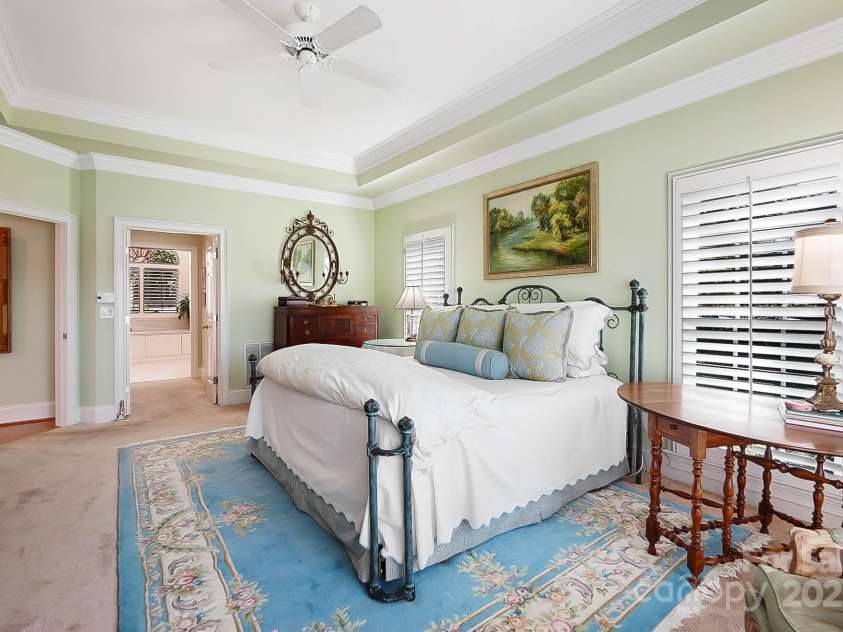 6403 Amos Smith Road, Charlotte, NC 28214.  MLS# CAR4233233, YatesRealty ID 13507. Wake up to the serene beauty of the lake from the luxurious primary suite on the main floor boasting tray ceilings, sitting area, fireplace, and 2 walk-in closets
