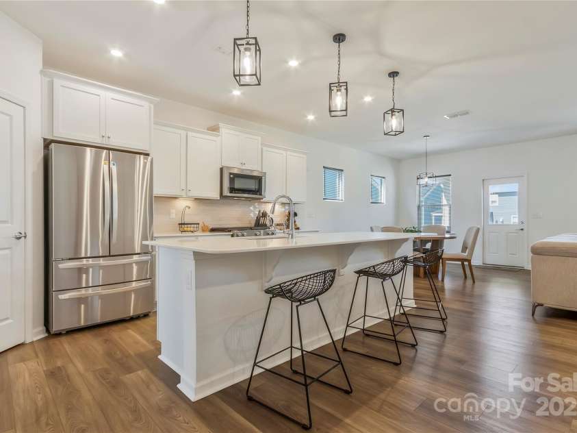 14224 Canemeadow Drive, Charlotte, NC 28278.  MLS# CAR4246314, YatesRealty ID 13517. Beautiful white kitchen with quartz countertops. Sellers added the pendent lights over the island. LG fridge will come with your new home.