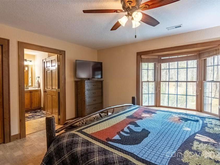 620 Sapphire Valley Road, Cashiers, NC 28717.  MLS# CAR4329121, YatesRealty ID 1359. En-Suite Bed/Bath #1 looking over the Horsepasture River out back. Lots of light in thru the large bay windows.