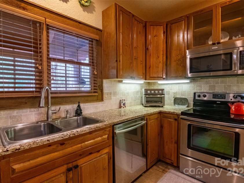 620 Sapphire Valley Road, Cashiers, NC 28717.  MLS# CAR4329121, YatesRealty ID 1359. Entering the front door, the kitchen is on the right, and the dining / living area is right in front of you. The kitchen boasts all stainless-steel appliances, and wonderful cabinetry and countertops.