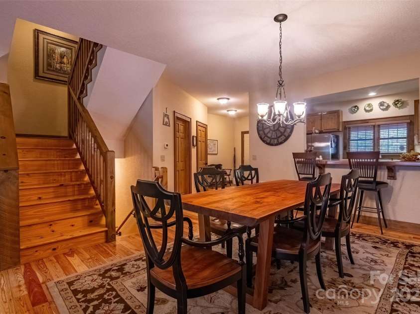 620 Sapphire Valley Road, Cashiers, NC 28717.  MLS# CAR4329121, YatesRealty ID 1359. Here you see the breakfast bar, half bath and foyer entry. The stairs take you up to the second floor with its bedrooms and 3 full baths. The dining room table and chair ensemble are included with the sale. 
