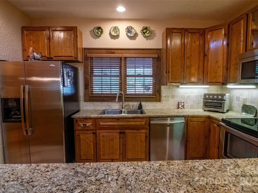 620 Sapphire Valley Road, Cashiers, NC 28717.  MLS# CAR4329121, YatesRealty ID 1359. The window of the kitchen window looks out to the front porch. Here you are looking from the dining area, over the breakfast bar, and into the kitchen. All matching countertops. breakfast bar, and lovely cabinets th