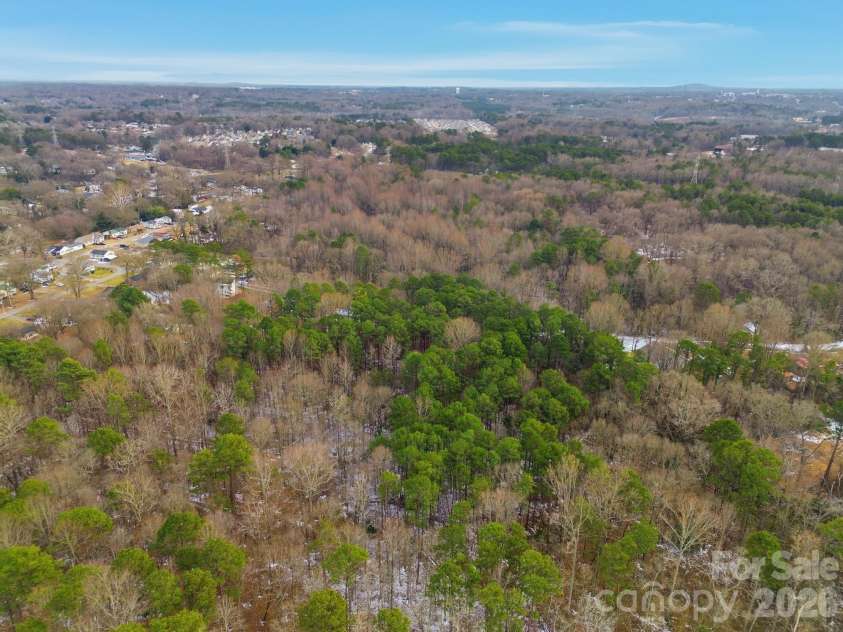 704 Border Street, Dallas, NC 28034.  MLS# CAR4342695, YatesRealty ID 1360. Aerial rear view of wooded area surrounding subject