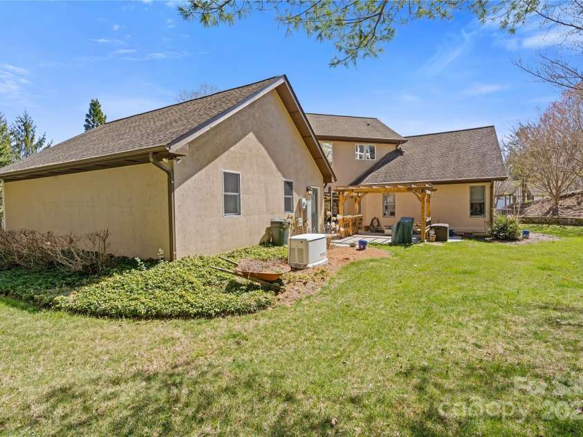 3001 Hickory Nut Trail, Hendersonville, NC 28739.  MLS# CAR4234402, YatesRealty ID 13641. Left side & back yard showing the generator & looking toward the pergola