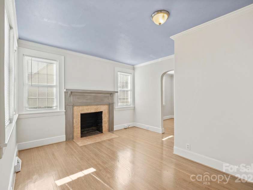 3724 Commonwealth Avenue, Charlotte, NC 28205.  MLS# CAR4287119, YatesRealty ID 13643. Living Room with fireplace and gleaming wood floors throughout the home.