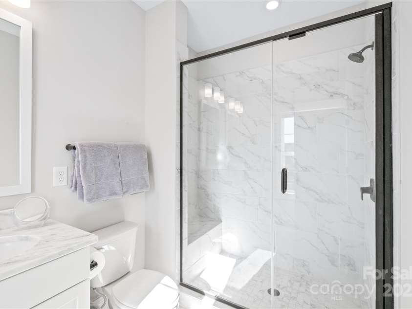 1066 Riverwalk Parkway, Rock Hill, SC 29730.  MLS# CAR4210322, YatesRealty ID 1366. Step into a luxurious walk-in shower featuring a semi-frameless surround, tile walls, and a built-in bench for ultimate convenience.