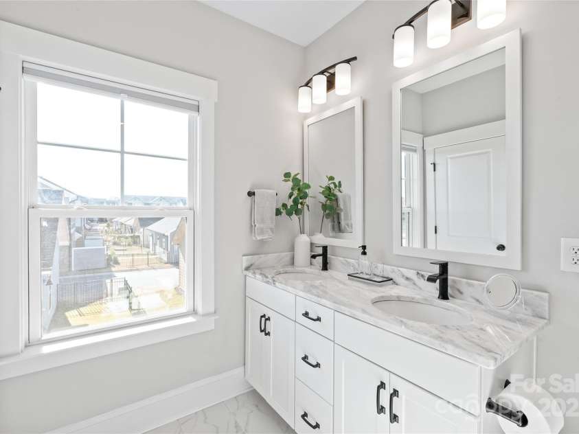 1066 Riverwalk Parkway, Rock Hill, SC 29730.  MLS# CAR4210322, YatesRealty ID 1366. The en-suite bathroom is a spa-like haven, featuring stunning tile floors, dual quartz sinks, an expansive shower, and plenty of natural light to brighten your day.