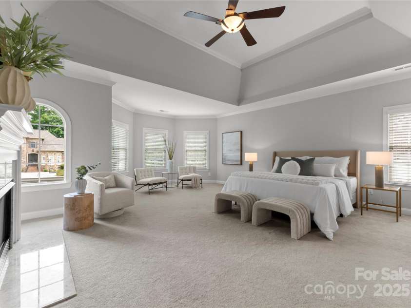 7005 Camrose Crossing Lane, Matthews, NC 28104.  MLS# CAR4248108, YatesRealty ID 13679. The primary suite is a luxurious sanctuary, offering inviting sitting areas, elegant fireplace, and a private retreat—perfect for a home office, yoga studio, or personal wellness space.