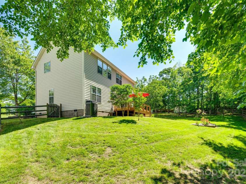9700 Stewart Spring Lane, Charlotte, NC 28216.  MLS# CAR4252858, YatesRealty ID 13687. Rear of home with fenced yard and lush landscaping