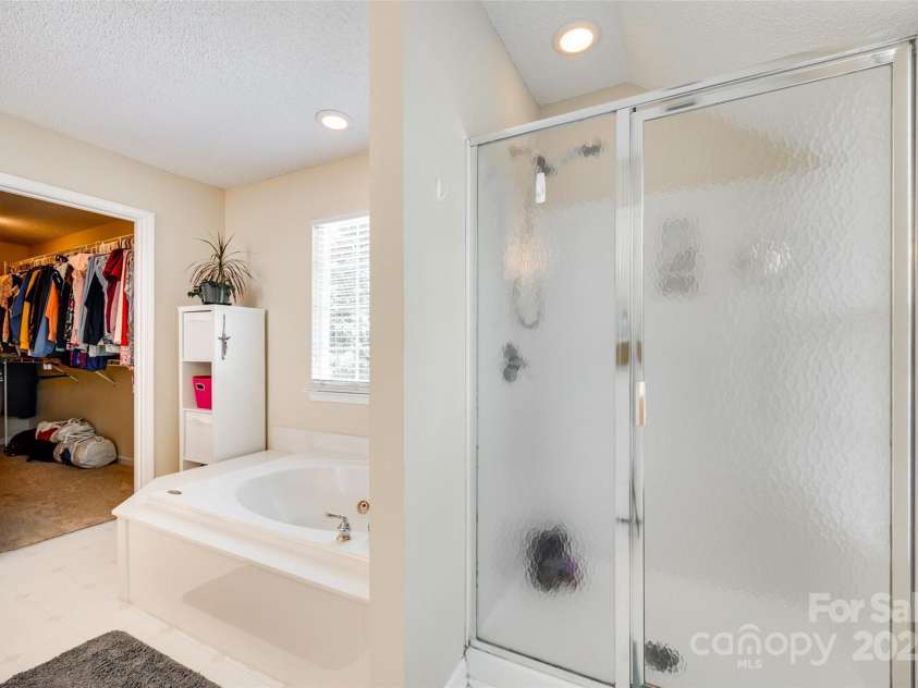 9700 Stewart Spring Lane, Charlotte, NC 28216.  MLS# CAR4252858, YatesRealty ID 13687. Shower and soaking tub in primary bathroom
