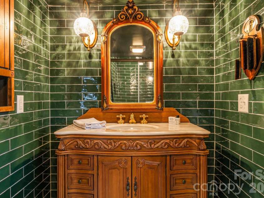 16 Decker Drive, Asheville, NC 28803.  MLS# CAR4355607, YatesRealty ID 13690. The primary ensuite bathroom features designer ceramic tile, a new vanity and sconce lighting.