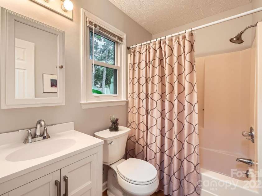 4145 Wall Street, Charlotte, NC 28209.  MLS# CAR4215362, YatesRealty ID 13725. Primary en-suite with tub/shower combo and vanity with lots of storage.