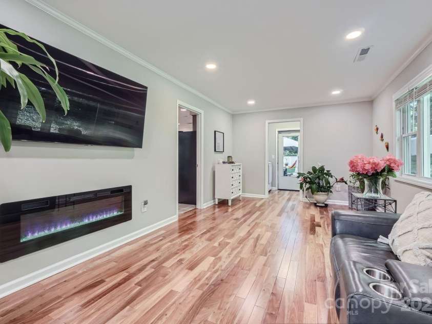 4145 Wall Street, Charlotte, NC 28209.  MLS# CAR4215362, YatesRealty ID 13725. The den offers a cozy fireplace and and abundance of windows. The wood flooring carries through here as well.
